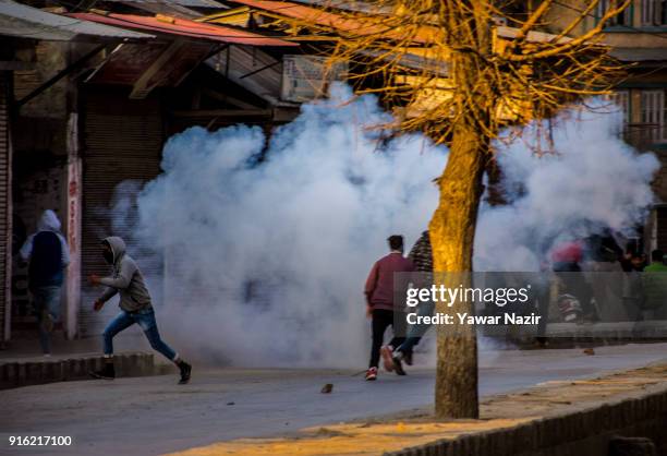 Kashmiri Muslims protest save themselves from the teargas shells fired towards them by Indian government forces as they withdraw from the restriction...