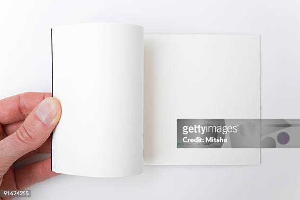 open white book - a hand flipping pages. - notepad template stock pictures, royalty-free photos & images