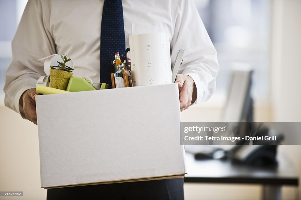 A businessman with a box full of desk stuff