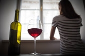 Woman drinking wine alone in the dark room