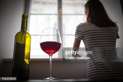 Woman drinking wine alone in the dark room Woman drinking wine alone in the dark room