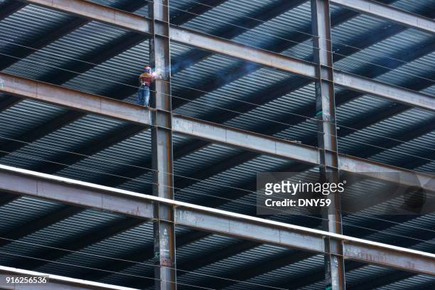bau arbeiter schweißen lichtstrahl auf hohe aufstieg gebäude - high rise stock-fotos und bilder