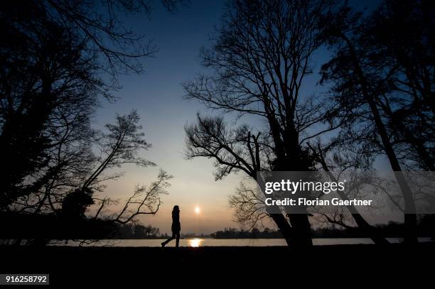 Woman walks along the Havel river during sunset on February 09, 2018 in Berlin, Germany.