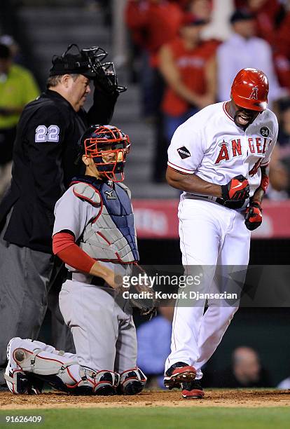 Torii Hunter of the Los Angeles Angels of Anaheim reacts to hitting a three-run home run as catcher Victor Martinez of the Boston Red Sox look on in...