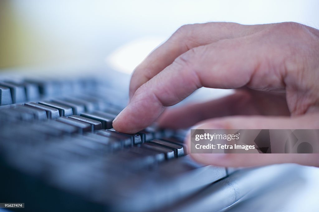 Hand typing on a computer keyboard