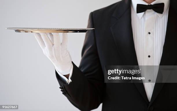 a server holding a silver tray - serving tray ストックフォトと画像