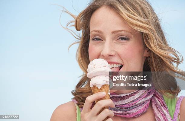 a woman eating ice cream - women licking women stock pictures, royalty-free photos & images