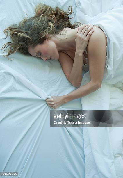 a woman sleeping in bed - 不穏状態 ストックフォトと画像