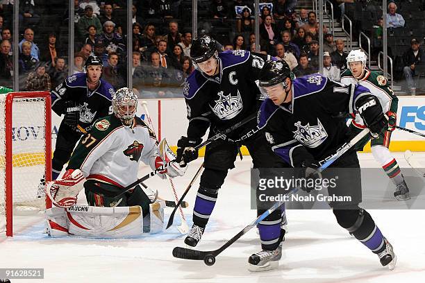 Justin Williams and Dustin Brown of the Los Angeles Kings fight in front of the net against Josh Harding of the Minnesota Wild on October 8, 2009 at...
