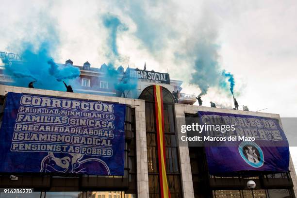 Members of far right group Hogar Social Madrid with smoke bombs in the rooftop of occupied building as police arrives for their eviction, which...