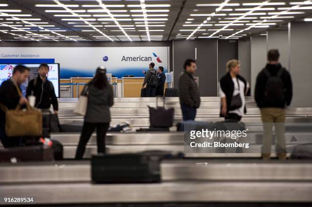 Travelers stand in the baggage claim area for American Airlines Group Inc. At O'Hare International Airport during a snow storm in Chicago, Illinois,...