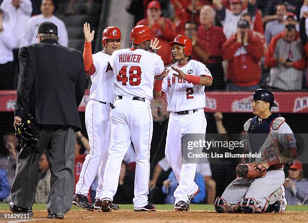 Torii Hunter of the Los Angeles Angels of Anaheim celebrates with teammates Bobby Abreu and Erick Aybar after hitting a three-run home run as catcher...