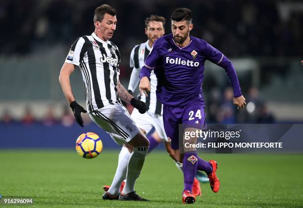 Fiorentina's midfielder Marco Benassi outruns Juventus's Croatian forward Mario Mandzukic during the italian Serie A football match Fiorentina vs...
