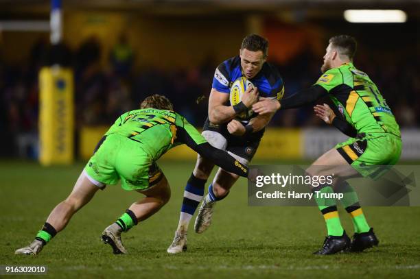 James Wilson of Bath Rugby is tackled by Tom Stephenson and Rob Horne of Northampton Saints during the Aviva Premiership match between Bath Rugby and...