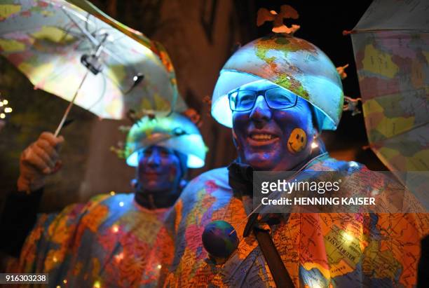 Revellers wearing a shining globe costume participate at the Eiserfeyer Carnival lights train in Eiserfrey, western Germany, on February 9, 2018. /...