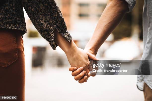 heckansicht des ein paar auf der straße laufen - holding hands stock-fotos und bilder