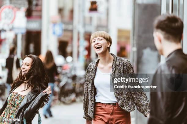 women friends walking together on the city - guy girl street laugh stock pictures, royalty-free photos & images