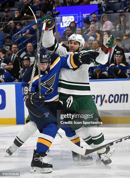 St. Louis Blues defenseman Vince Dunn and Minnesota Wild defenseman Mike Reilly compete for the puck during an NHL game between the Minnesota Wild...