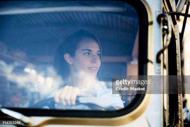 young saleswoman looking away while driving food truck - truck driver stock pictures, royalty-free photos & images