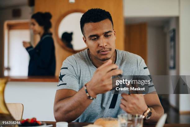 man checking blood sugar level while having breakfast at home - diabetes technology stock pictures, royalty-free photos & images