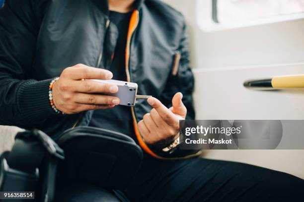 man doing blood test with glaucometer while sitting in train - glaucometer stockfoto's en -beelden