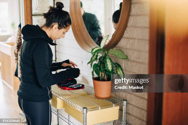 woman checking diabetes kit while standing in front of mirror at home - woman-looking-into-mirror-full-body stock pictures, royalty-free photos & images