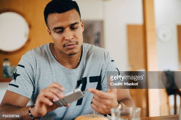 mid adult man using glaucometer while having breakfast at home - glaucometer stockfoto's en -beelden