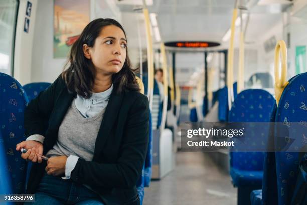 woman using injection pen while sitting in train - injecting pen stock pictures, royalty-free photos & images