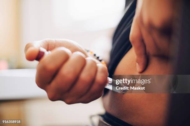 close-up of businessman injecting insulin in abdomen in office - diabetes stockfoto's en -beelden