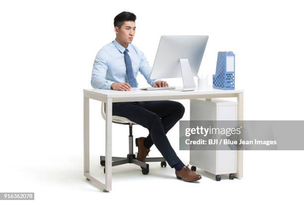 serious young businessman working in office - asian man seated stockfoto's en -beelden