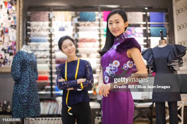 fashion designer examining dress on customer - cheongsam stock pictures, royalty-free photos & images