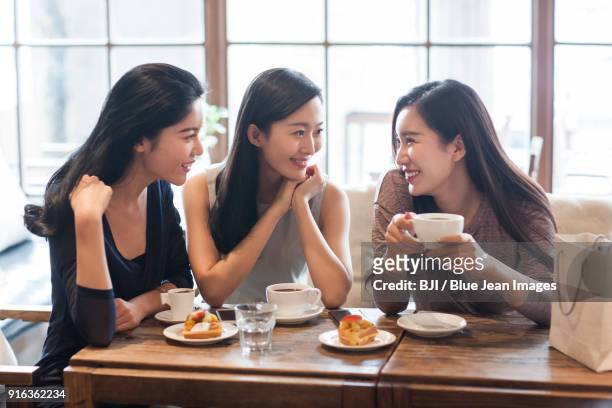 best female friends drinking coffee in caf¨¦ - asian friends coffee stock-fotos und bilder