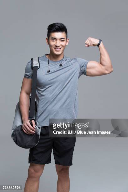 cheerful young male athlete flexing muscles - strongman foto e immagini stock