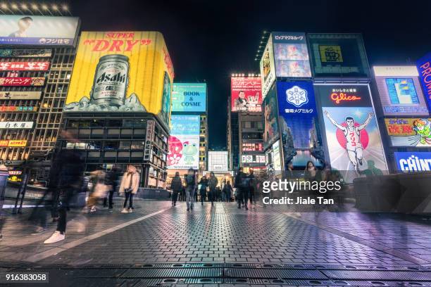 busy tourists waliking in dotonbori at night - osaka prefecture stock pictures, royalty-free photos & images