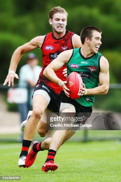 Zach Merrett of the Bombers runs with the ball from Michael Hurley of the Bombers during the Essendon Bombers AFL Intra-Club Match at The Hangar on...