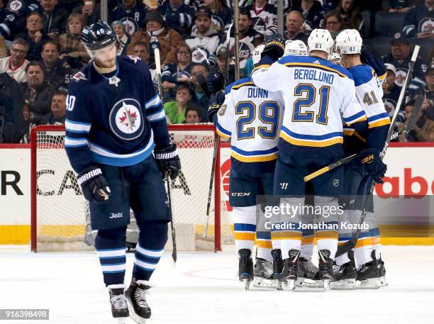 Joel Armia of the Winnipeg Jets skates away as Vince Dunn, Brayden Schenn, Patrik Berglund and Robert Bortuzzo of the St. Louis Blues celebrate a...