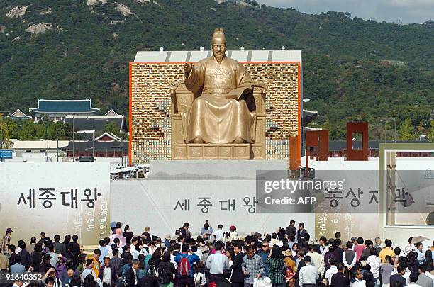 Spectators gather in front of a bronze statue of King Sejong after a ceremony marking the 563rd anniversary of the creation of the Korean alphabet,...