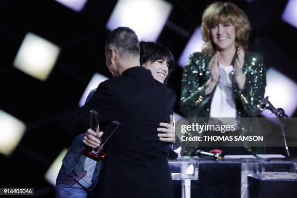 French actress and singer Charlotte Gainsbourg hughs as she gives French singer Etienne Daho a special honour award during the 33rd Victoires de la...