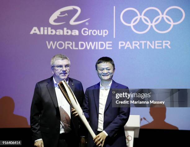 President Thomas Bach presents an Olympic Torch to Alibaba Group Executive Chairman Jack Ma during the unveiling of the Alibaba Showcase at the...