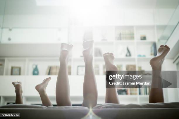 three kids upside down with feet up - kids feet in home stock-fotos und bilder