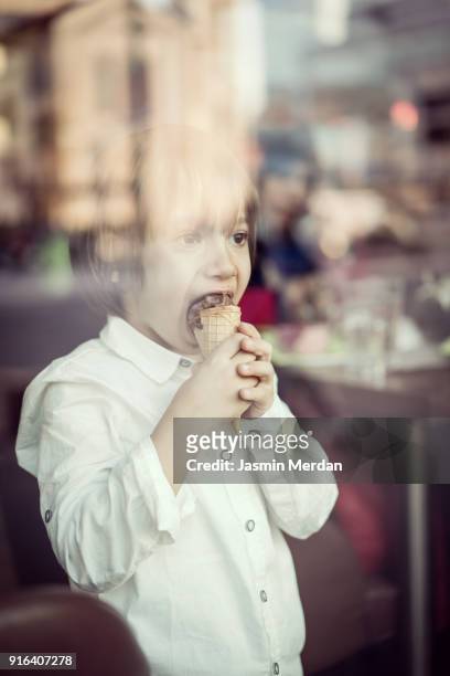 Child with ice cream behind glass