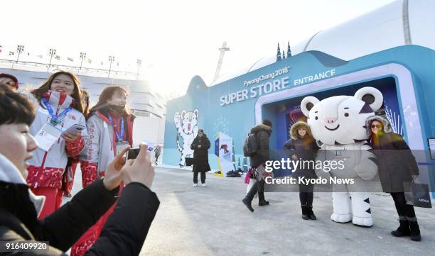 Visitors pose for photos with Pyeongchang Olympics mascot Soohorang near the Olympic Stadium, the venue of the Winter Games' opening ceremony, in...