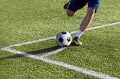 Footballer is preparing to give a corner kick with the ball