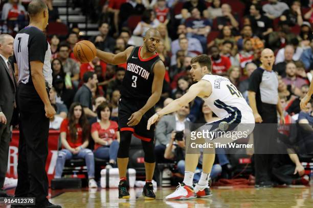Chris Paul of the Houston Rockets controls the ball defended by Juan Hernangomez of the Denver Nuggets in the second half at Toyota Center on...