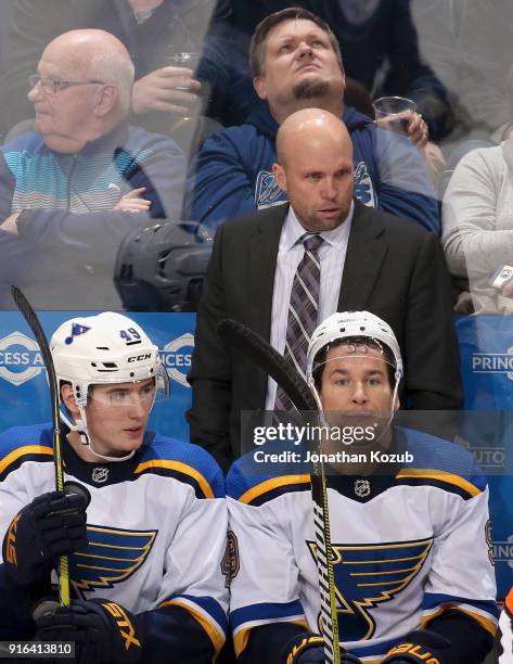 Head Coach Mike Yeo, Ivan Barbashev and Scottie Upshall of the St. Louis Blues look on from the bench during third period action against the Winnipeg...