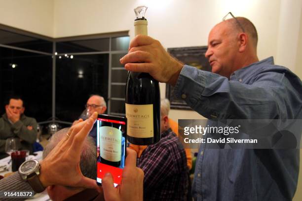 An Israeli man uses the Vivino wine app on his Samsung mobile phone to find out more information about the wine being served at a tasting of wines...