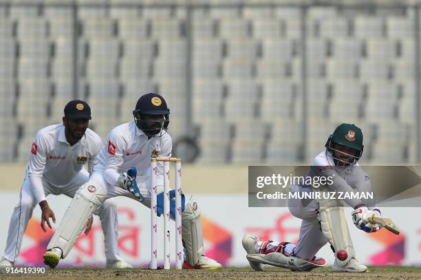 Bangladesh batsman Mominul Haque plays a shot as Sri Lanka's wicketkeeper Niroshan Dickwella and Dimuth Karunaratne look on during the third day of...