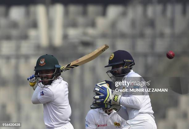 Bangladesh cricketer Mominul Haque plays a shot as the Sri Lanka wicketkeeper Niroshan Dickwella looks on during the third day of the second cricket...