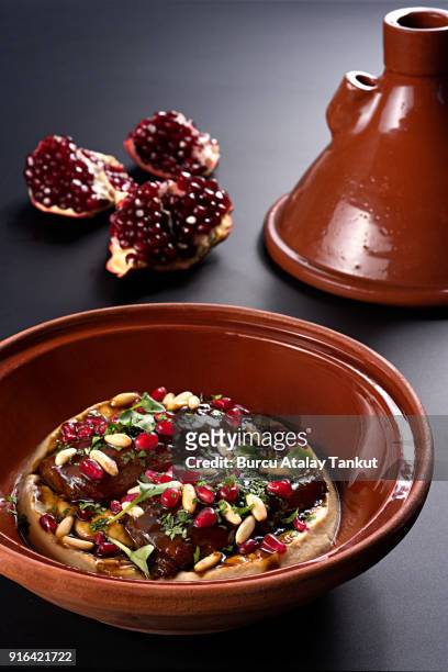 meat dish with hummus and pomegranate in tajine - tajine stock pictures, royalty-free photos & images