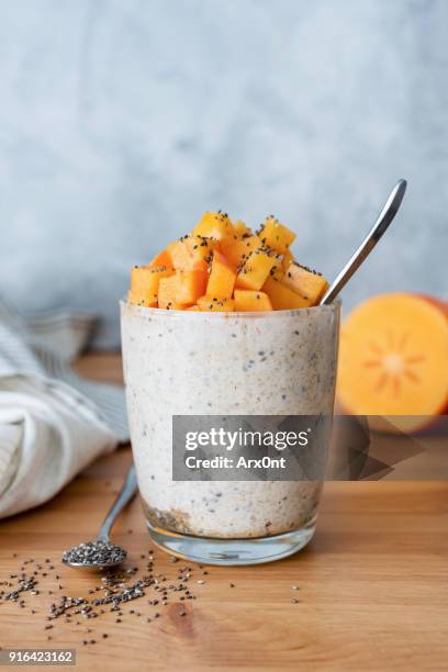 chia seed pudding with persimmon in glass - bocksdornfrucht stock-fotos und bilder